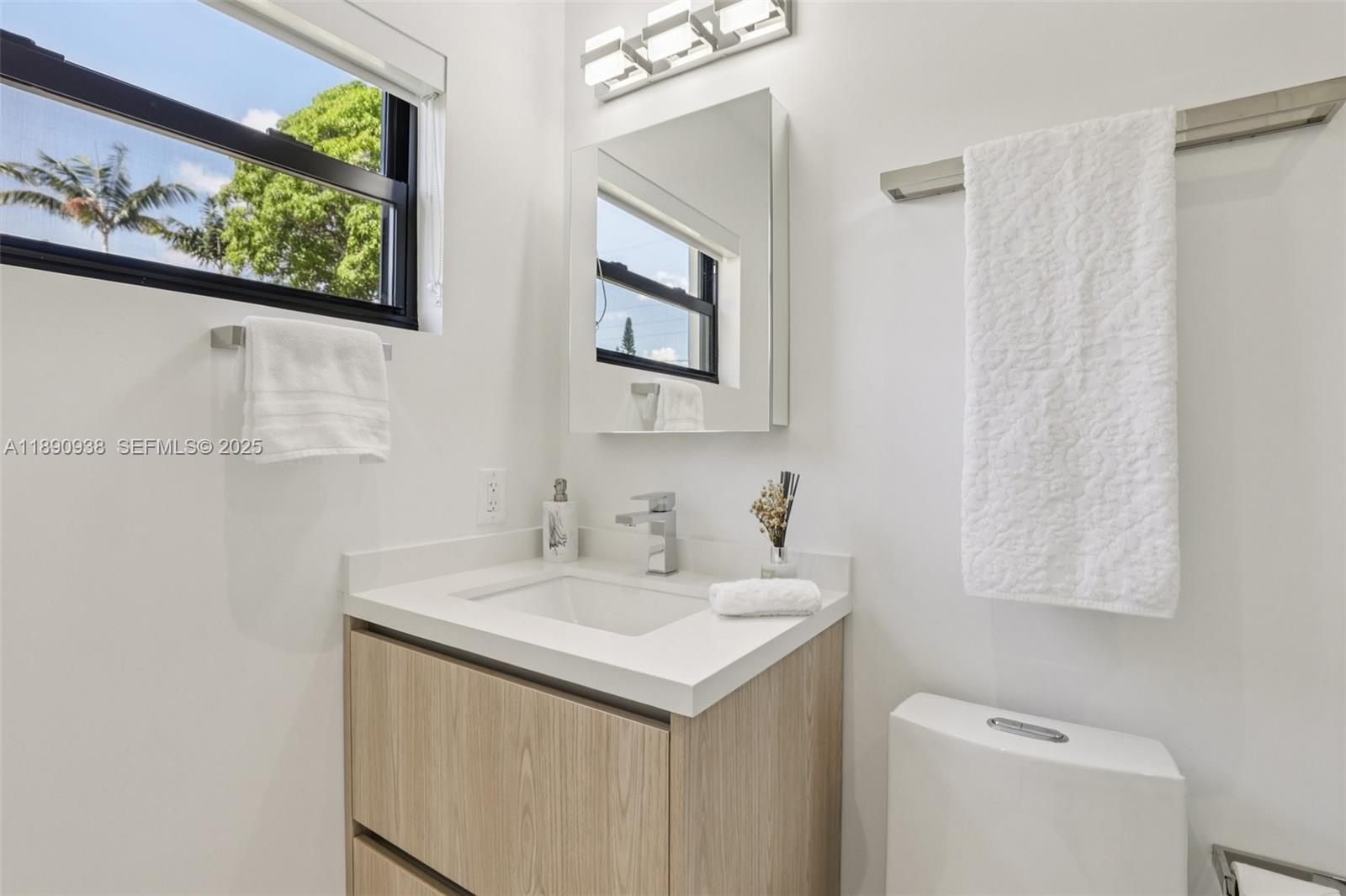 1960 Northeast 32nd Street Lighthouse Point, FL 33064 - Photo 24 of 40 a bathroom with a sink and a mirror