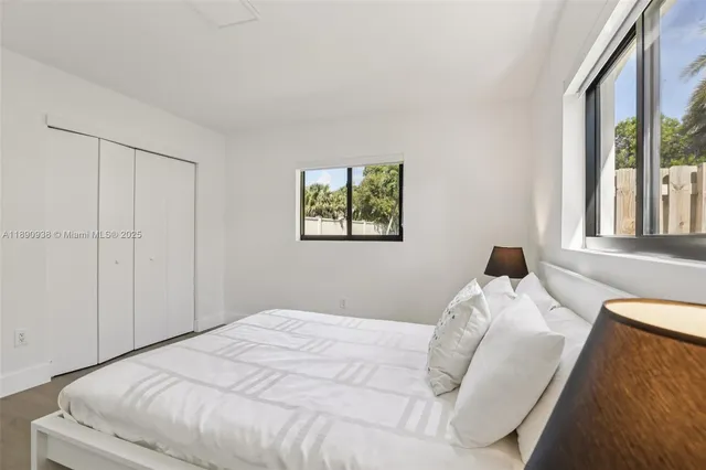 a bedroom with a bed and a large window