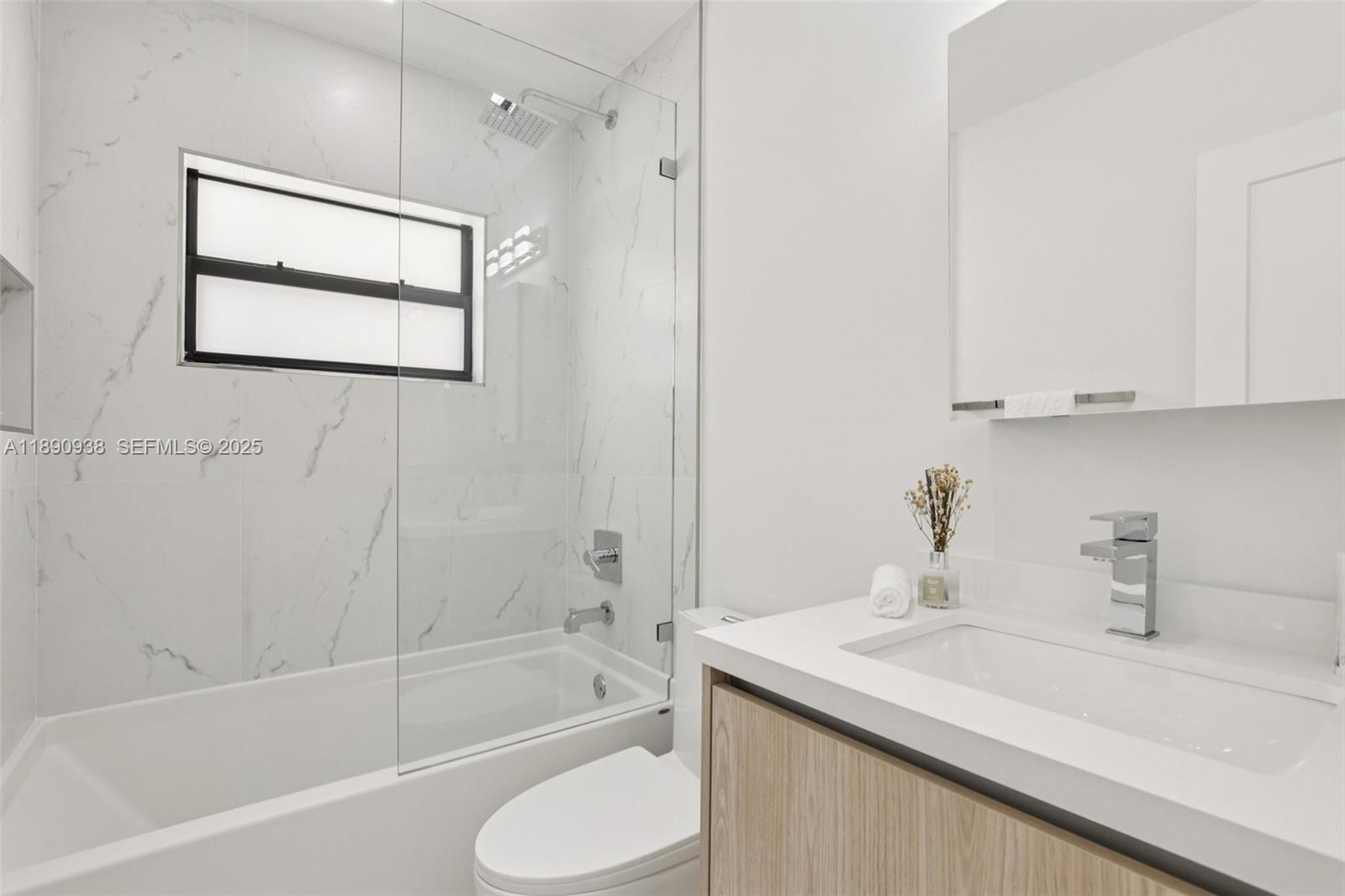 1960 Northeast 32nd Street Lighthouse Point, FL 33064 - Photo 29 of 40 a bathroom with a granite countertop sink mirror toilet and bathtub