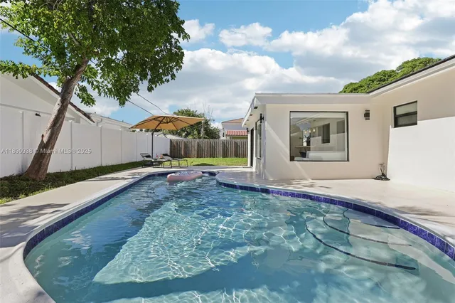 a view of a house with backyard and sitting area