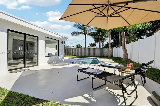 a view of a patio with table and chairs under an umbrella