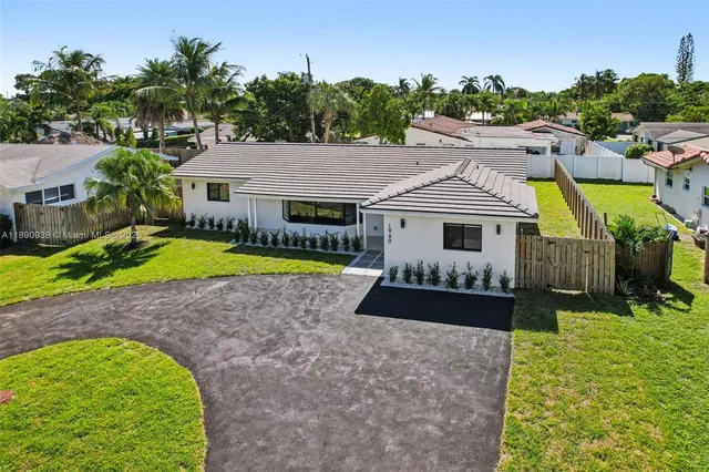 a front view of a house with a garden and swimming pool