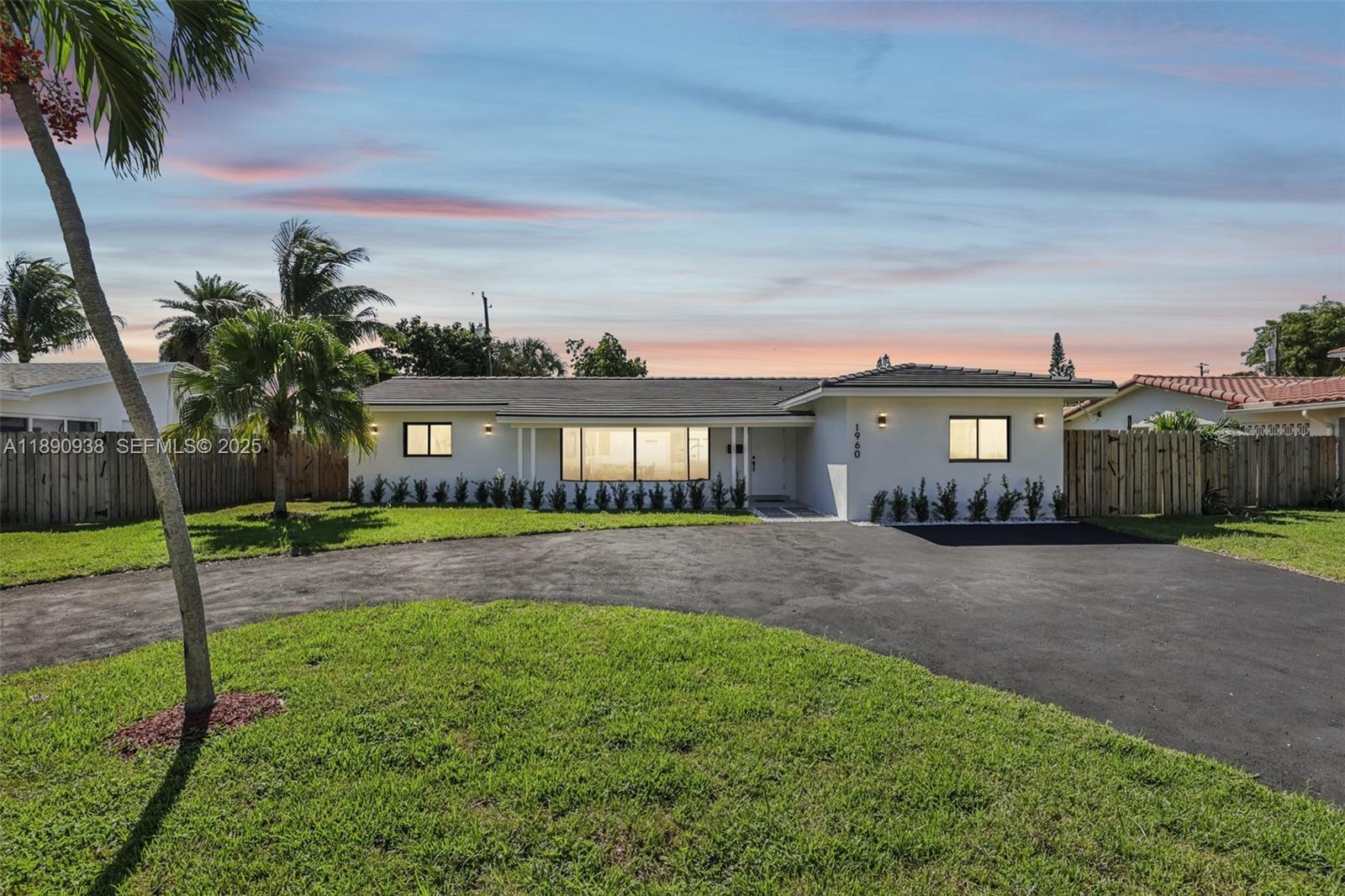 1960 Northeast 32nd Street Lighthouse Point, FL 33064 - Photo 40 of 40 a front view of a house with a yard and glass windows