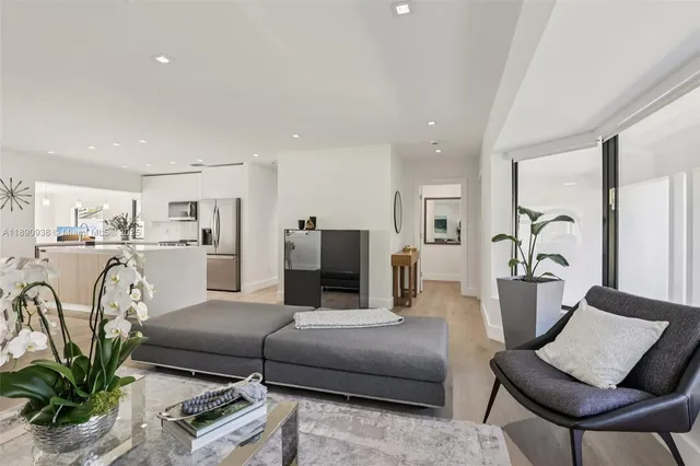 a living room with furniture white walls and a dining table