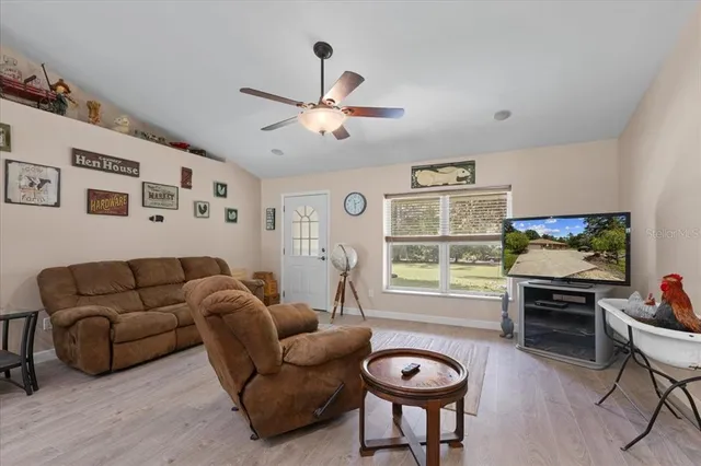 a living room with furniture a window and a flat screen tv