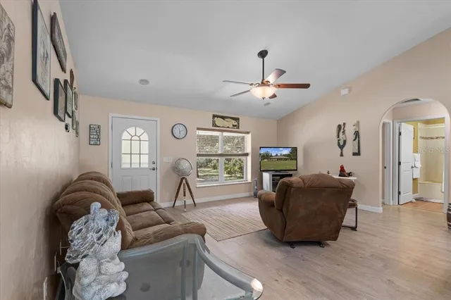 a living room with furniture a flat screen tv and a large window