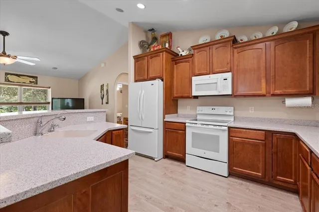 a kitchen with granite countertop a sink a counter top space appliances and cabinets