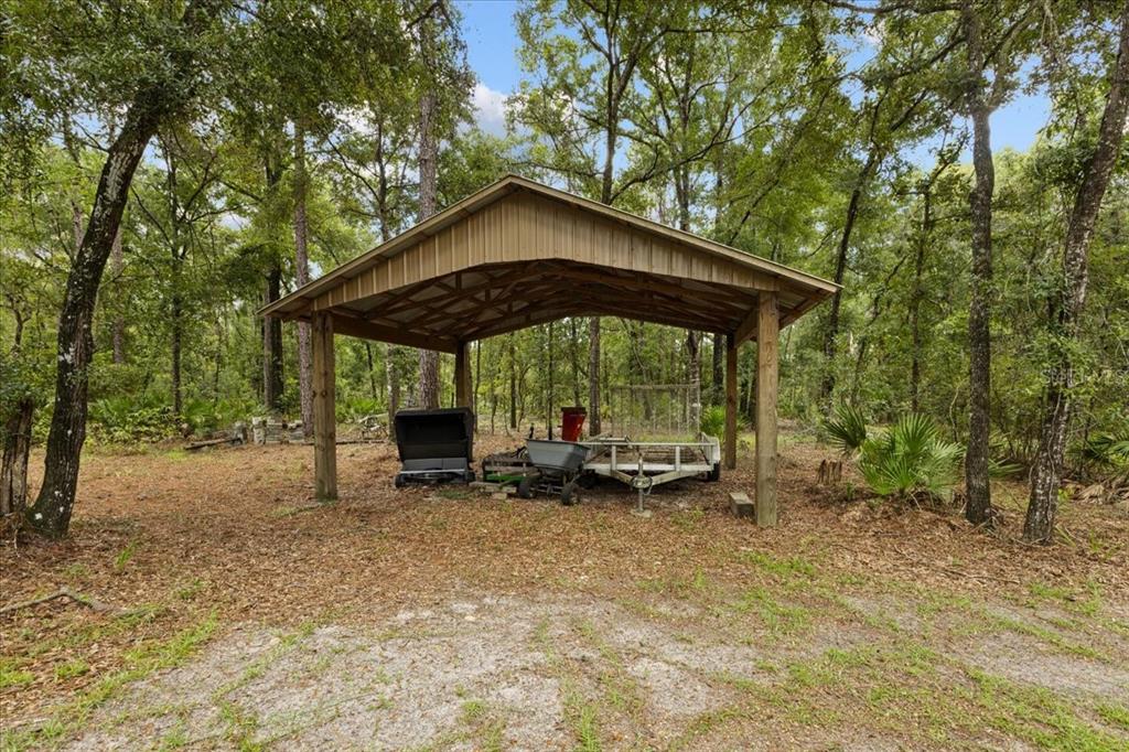 4700 Northwest 55th Avenue Bell, FL 32619 - Photo 49 of 77 a view of a wooden table and chairs under an umbrella