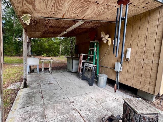 4700 Northwest 55th Avenue Bell, FL 32619 - Photo 60 of 77 a view of a patio with table and chairs potted plants with wooden floor and fence
