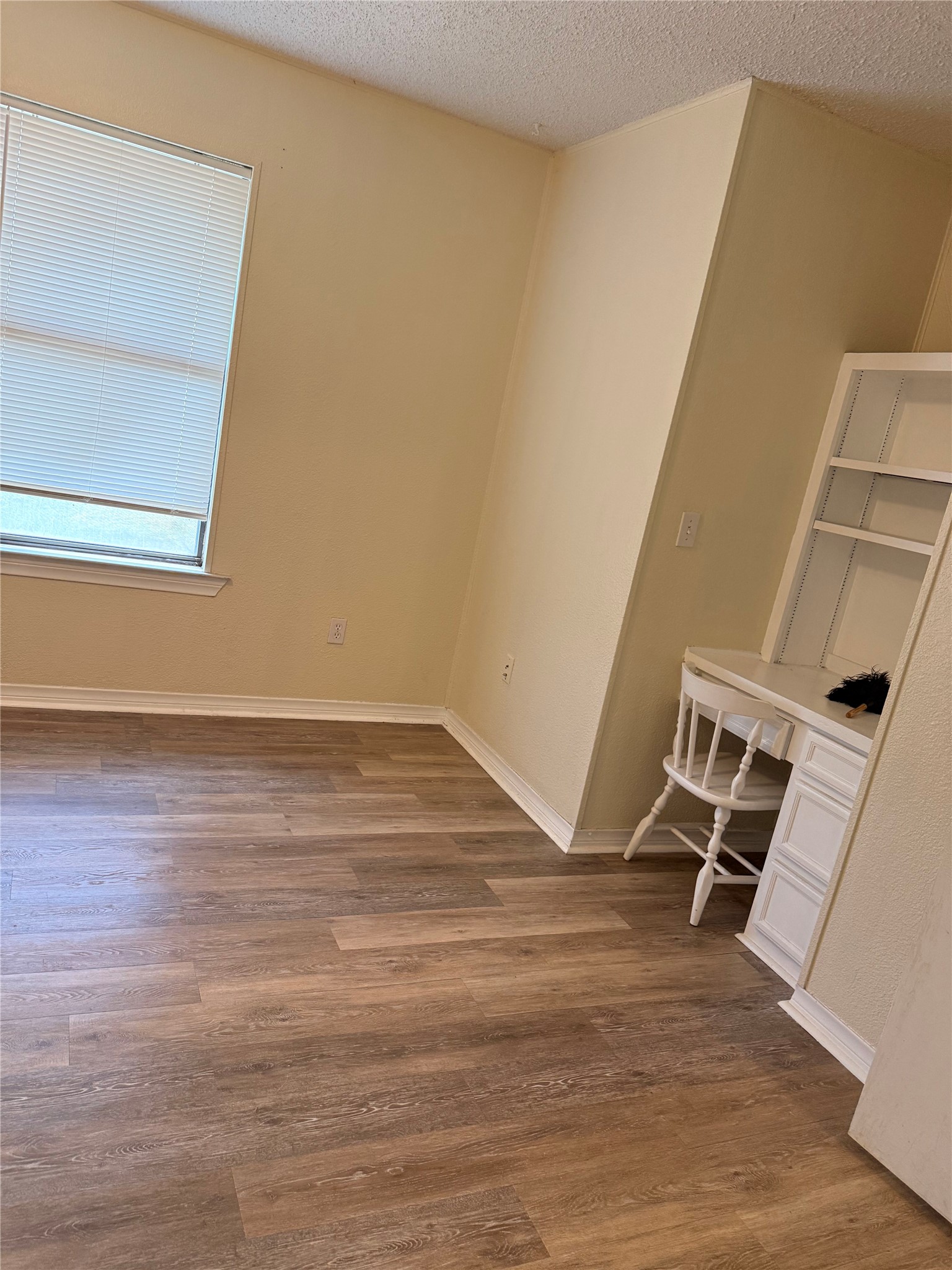5931 Limmer Loop Hutto, TX 78634 - Photo 12 of 22 Spare room with a textured ceiling, dark wood-type flooring, and a desk