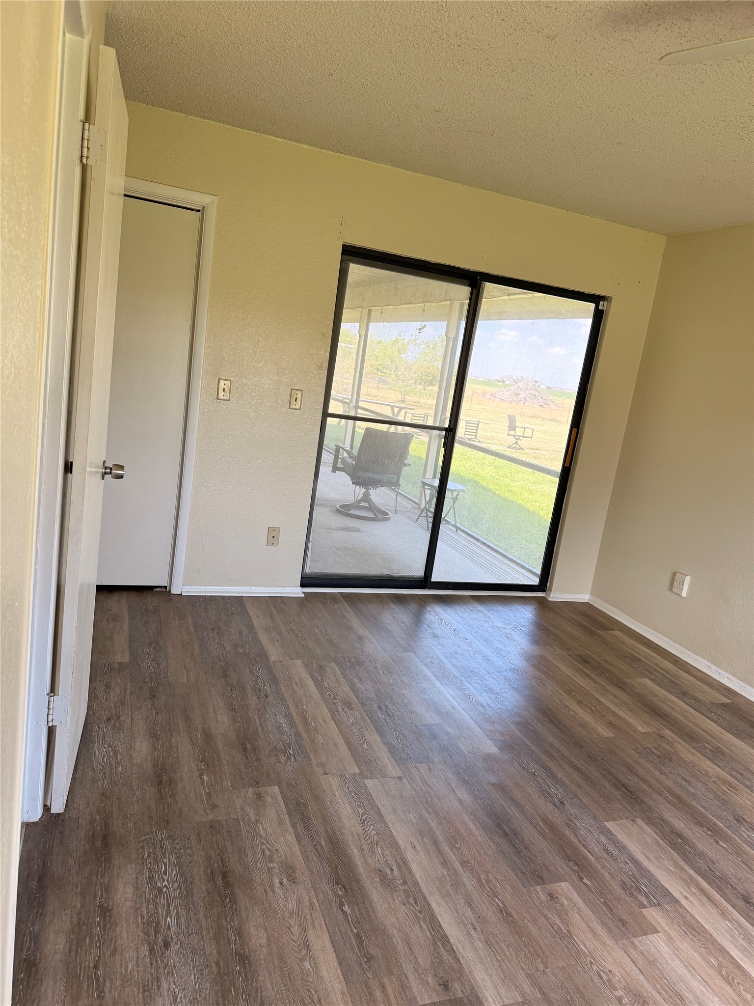 5931 Limmer Loop Hutto, TX 78634 - Photo 17 of 22 Unfurnished room with a textured ceiling and dark wood-style floors