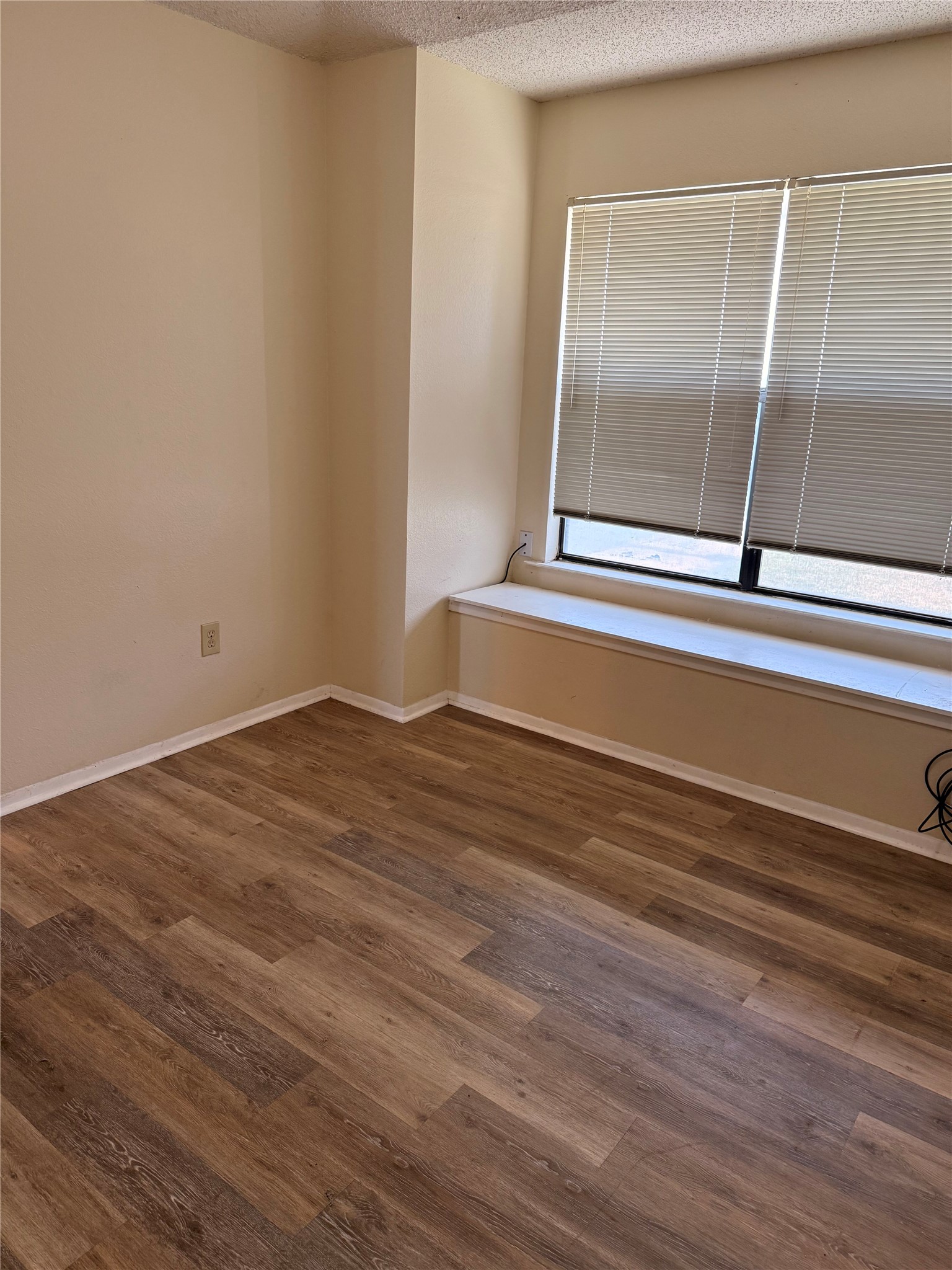 5931 Limmer Loop Hutto, TX 78634 - Photo 6 of 22 Empty room featuring dark wood-style floors and a textured ceiling