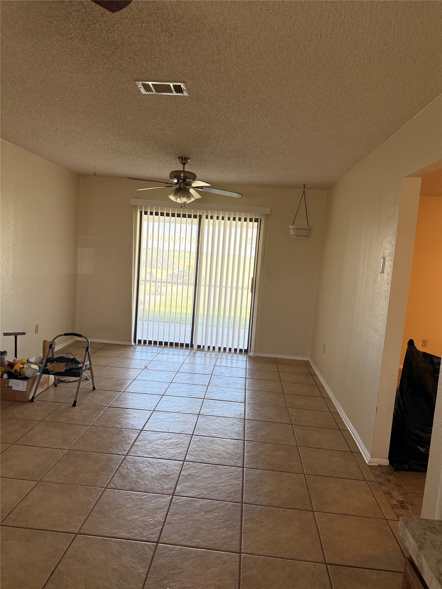 5931 Limmer Loop Hutto, TX 78634 - Photo 9 of 22 Unfurnished room with light tile patterned floors, a textured ceiling, and a ceiling fan