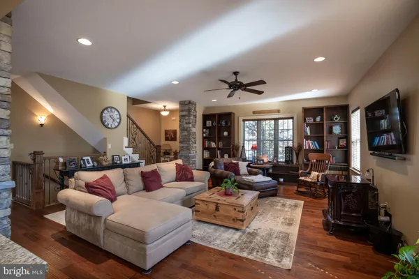 a living room with furniture kitchen view and a large window