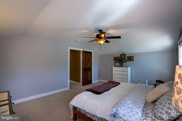 a view of a room with fridge and wooden floor