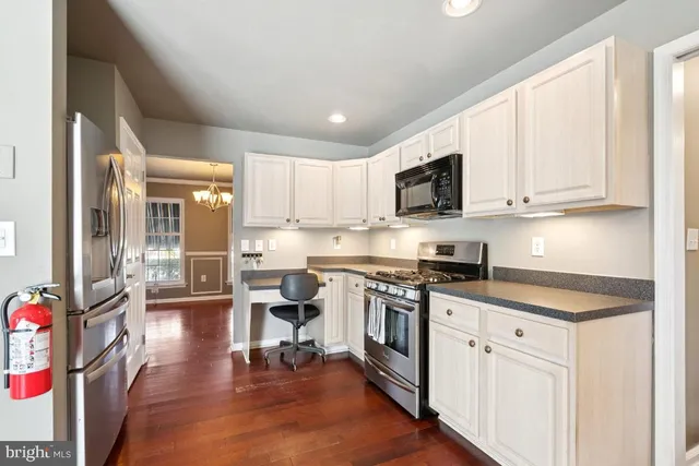 a kitchen with stainless steel appliances granite countertop a stove a sink dishwasher and a microwave oven with cabinets