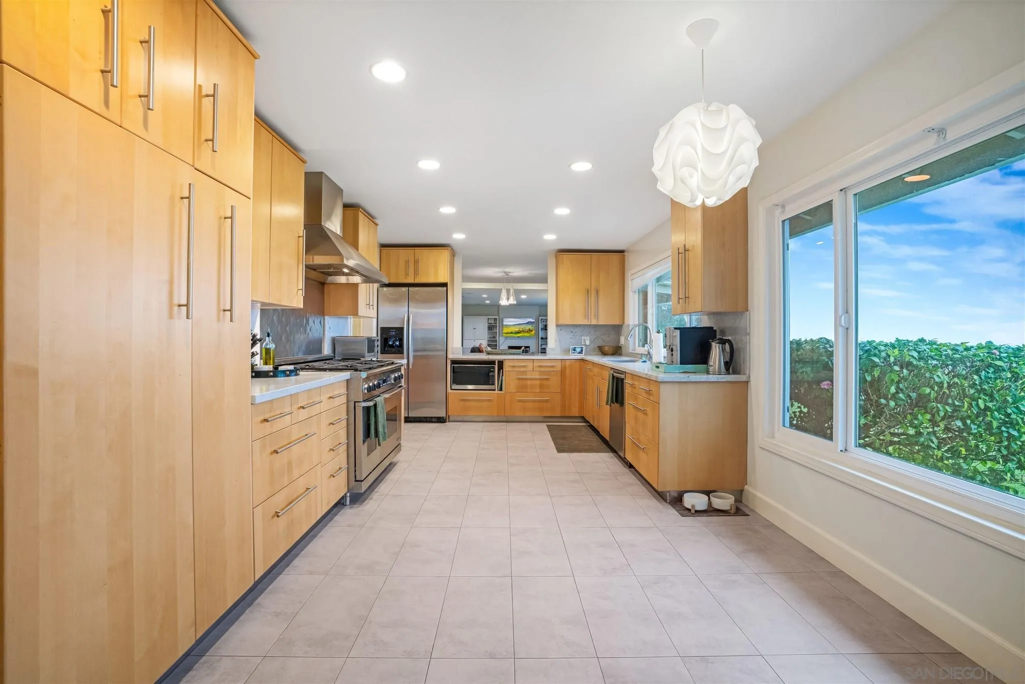 7356 Rue Michael La Jolla, CA 92037 - Photo 28 of 48 a large kitchen with kitchen island a large counter top stainless steel appliances and cabinets