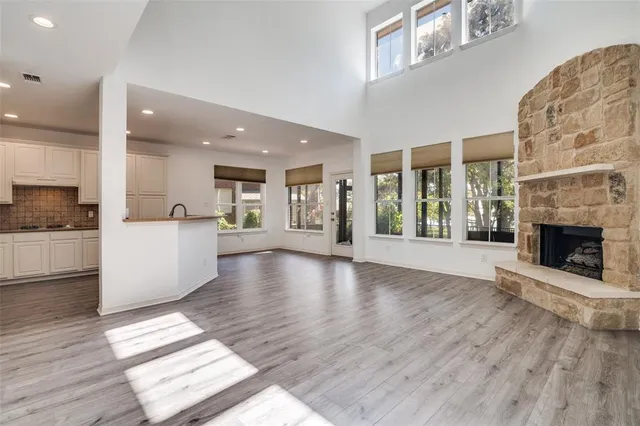 a view of a living room kitchen with a fireplace and wooden floor