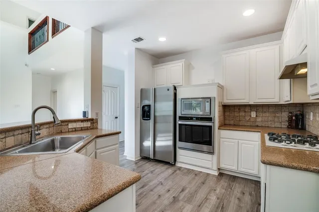 a kitchen with a refrigerator sink and cabinets
