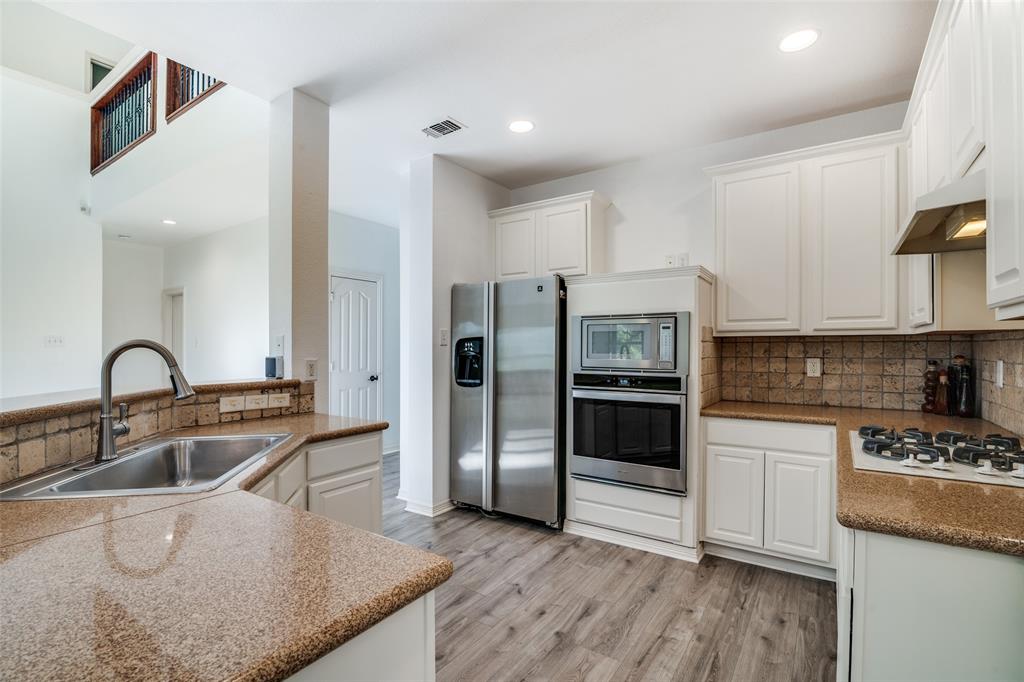 8810 Edgelake Trail Rowlett, TX 75088 - Photo 6 of 20 a kitchen with a refrigerator sink and cabinets