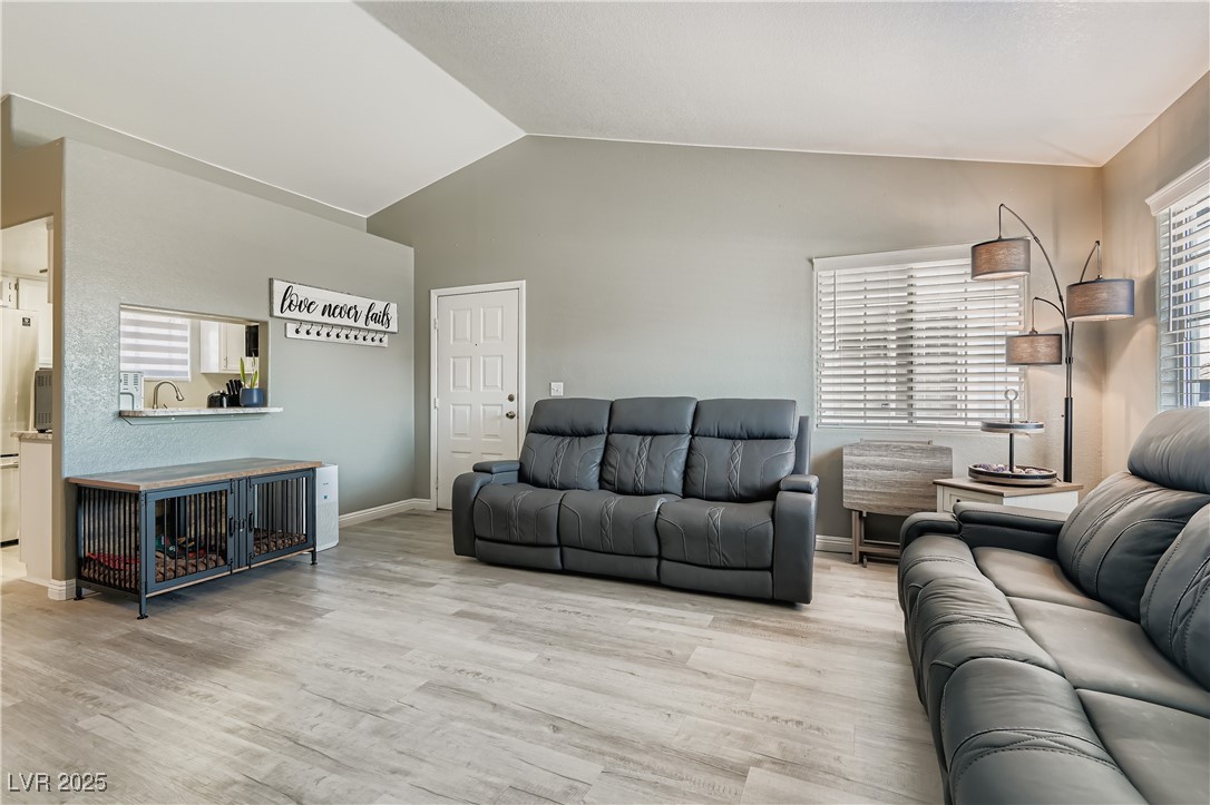 Living room featuring lofted ceiling and new flooring