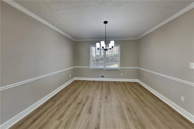 a view of wooden floor chandelier and window in a room
