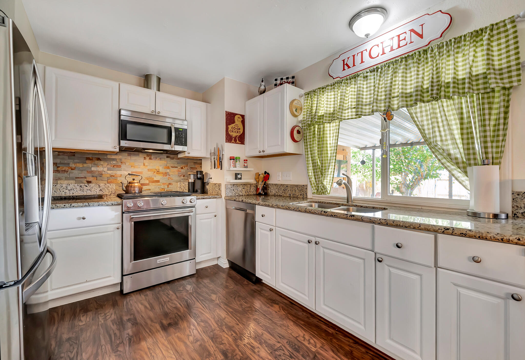 209 North Sunland Drive Ridgecrest, CA 93555 - Photo 13 of 51 a kitchen with stainless steel appliances granite countertop a stove a sink and a white wooden cabinets