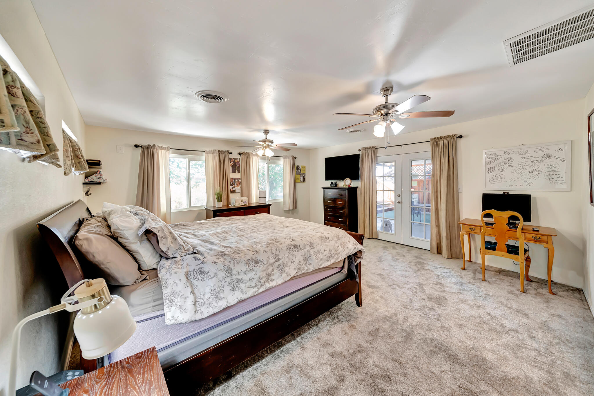 209 North Sunland Drive Ridgecrest, CA 93555 - Photo 30 of 51 a spacious bedroom with a large bed a fireplace and a chandelier