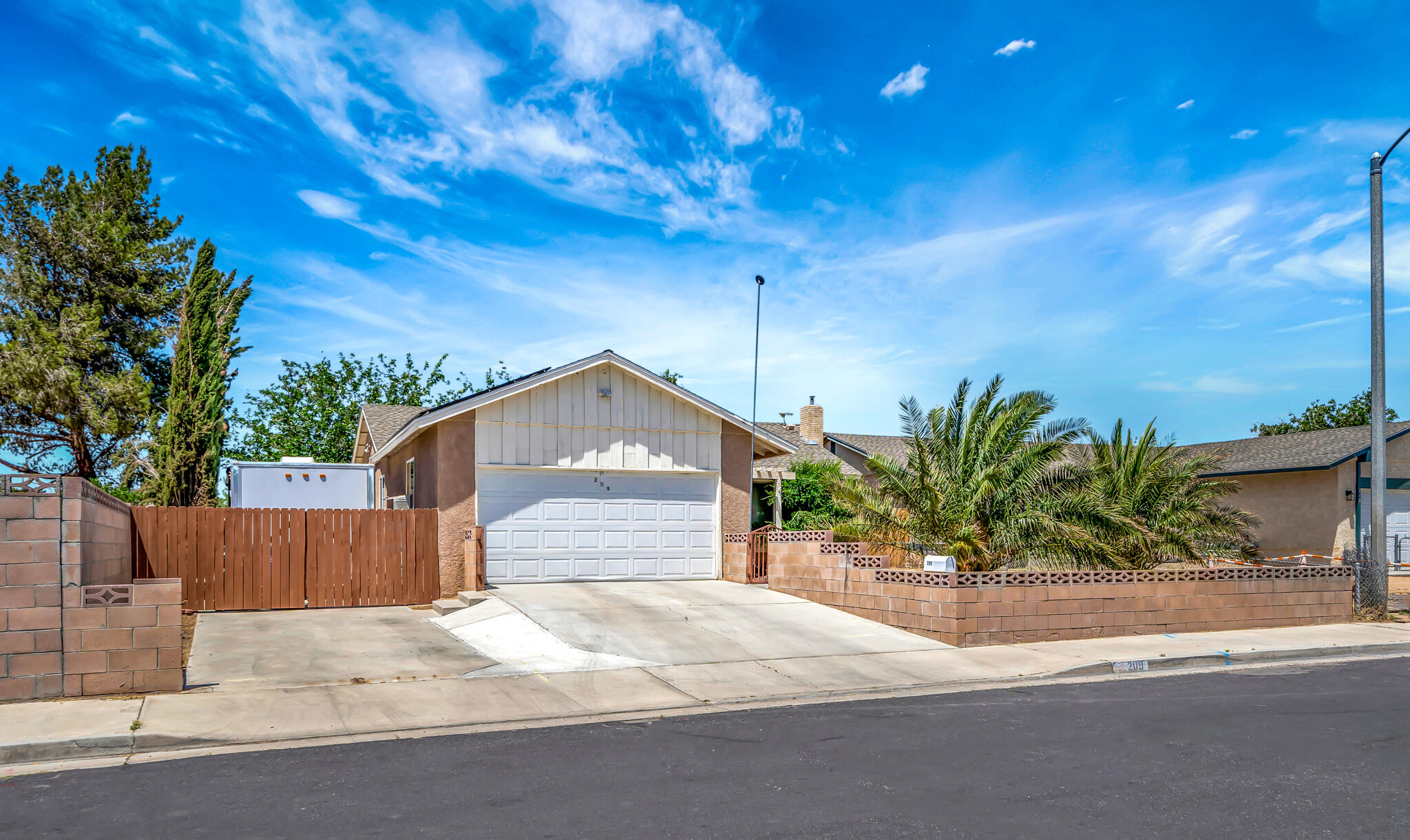 209 North Sunland Drive Ridgecrest, CA 93555 - Photo 47 of 51 a front view of a house with a yard and garage
