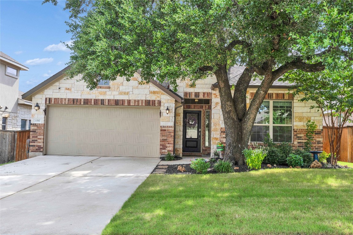 front view of a house with a yard and an trees