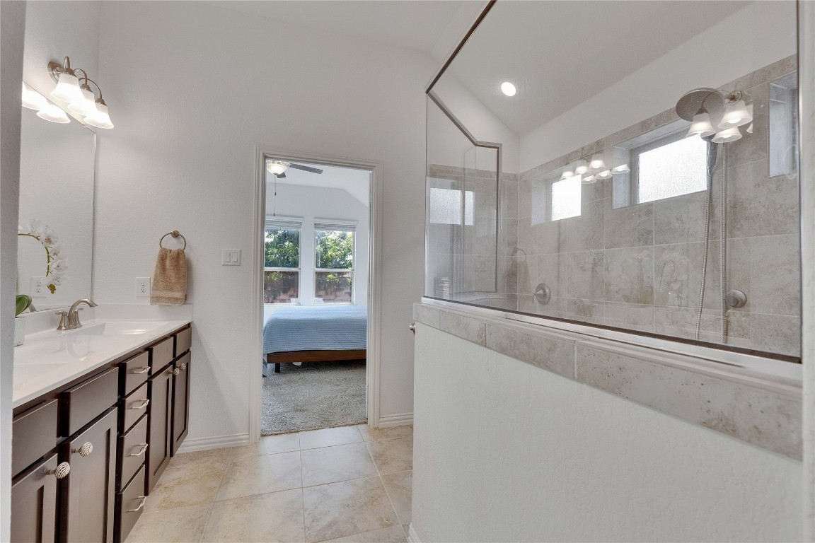 1312 Terrace View Drive Georgetown, TX 78628 - Photo 21 of 40 Ensuite bathroom with double vanity, a walk in shower, tile patterned floors, vaulted ceiling, and ceiling fan
