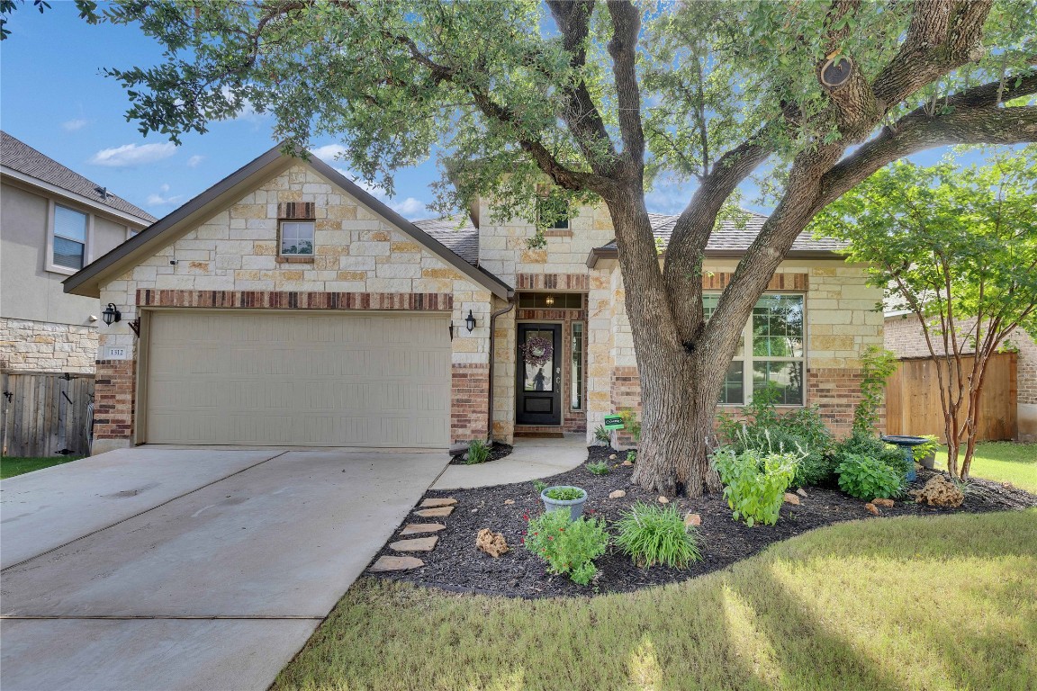 1312 Terrace View Drive Georgetown, TX 78628 - Photo 39 of 40 Gorgeous mature front tree, Stone and brick exterior, and plenty of parking in garage and driveway.