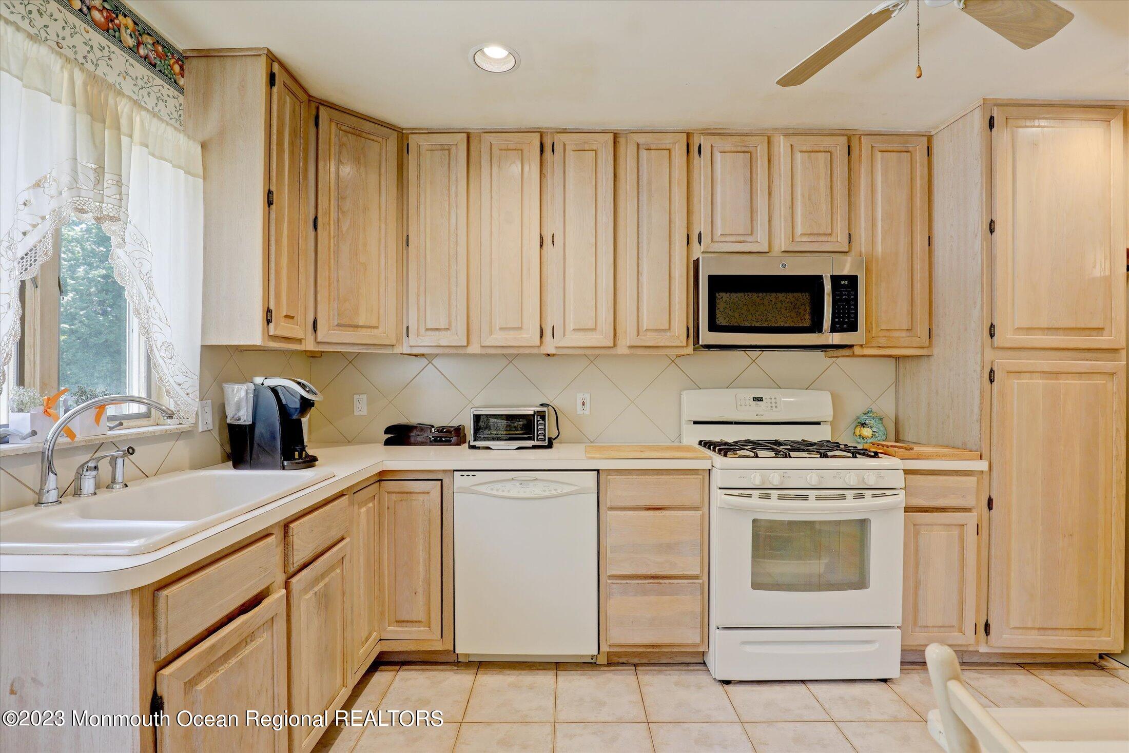 5 Ramble Way Hazlet, NJ 07730 - Photo 16 of 34 a kitchen with white cabinets and white appliances
