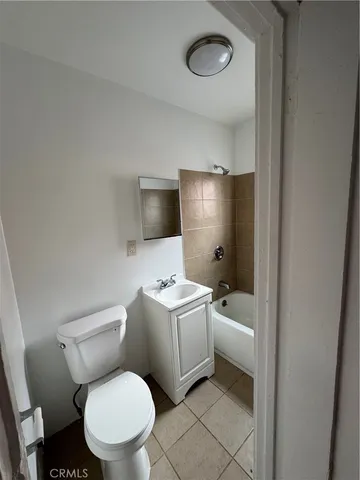 a white toilet sitting next to a white sink and vanity