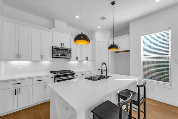 a kitchen with a table a sink and cabinets