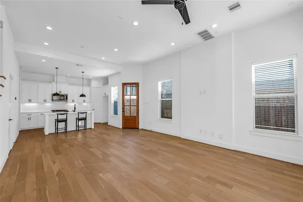 a view of a kitchen with stainless steel appliances wooden floor and a window