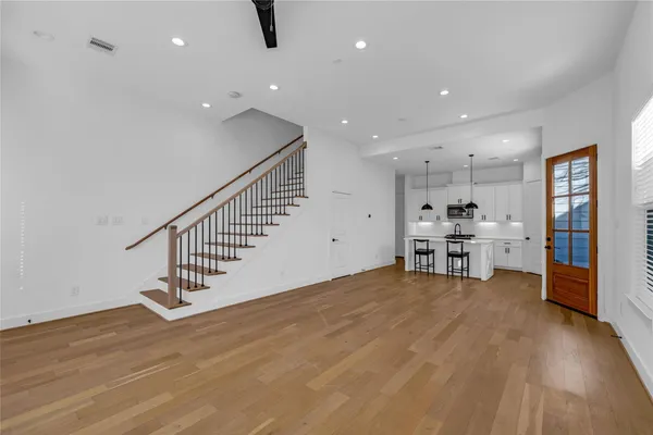 an empty room with wooden floor and stairs