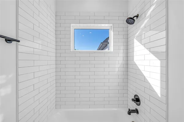 a bathroom with a window and a shower