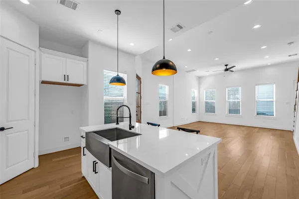 a kitchen with a sink a counter space and wooden floor