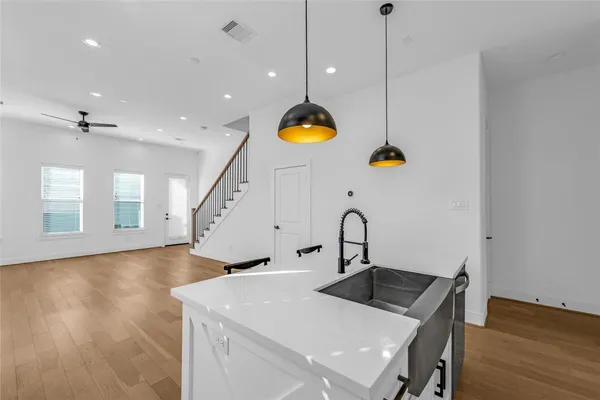 a kitchen with a sink a counter space and wooden floor