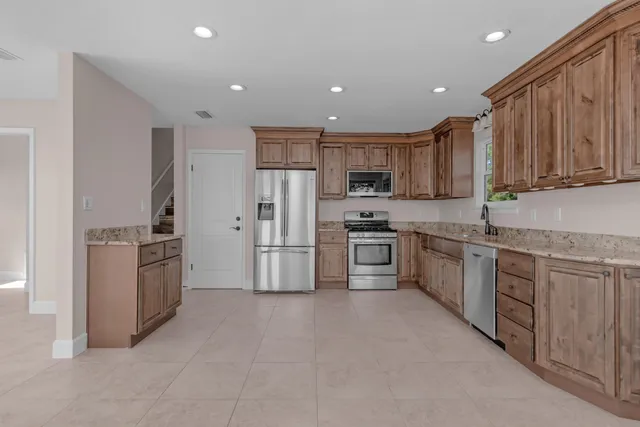 a kitchen with granite countertop white cabinets and stainless steel appliances