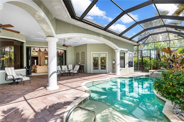 a view of a patio with table and chairs potted plants and floor to ceiling window