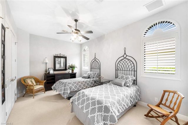 a bedroom with two beds and a chair