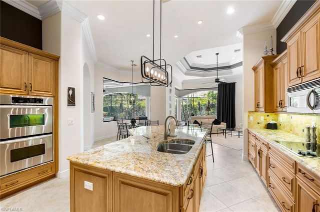 a kitchen with stainless steel appliances kitchen island granite countertop a sink and cabinets