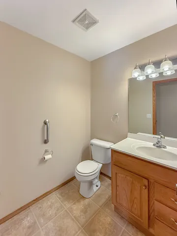 a bathroom with a granite countertop toilet a sink and a mirror