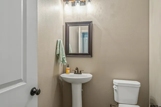 a bathroom with a toilet sink and mirror