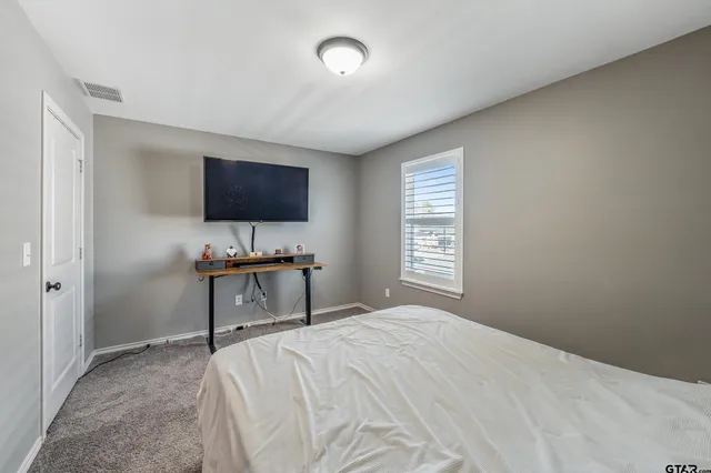 a bedroom with a bed and a flat screen tv