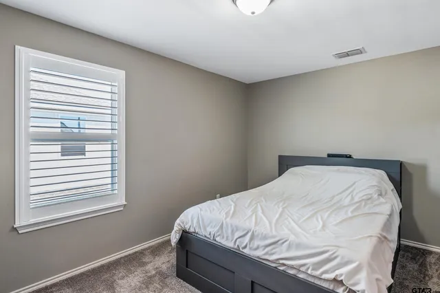 a bed sitting in a bedroom next to a window