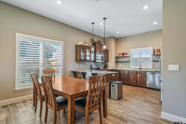 a view of a dining room and kitchen with a table chairs