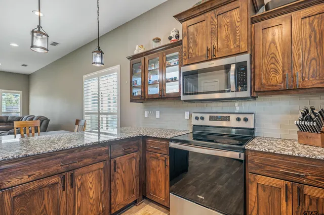 a kitchen with stainless steel appliances granite countertop stove microwave and cabinets